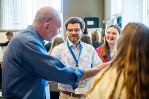 Judge with students at Poster Presentation